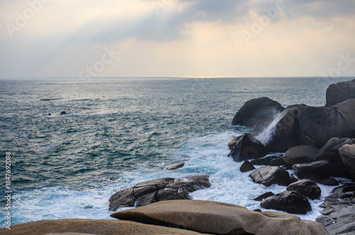The scenery of Stone Park in Hainan, China, features emerald-green seawater crashing against the rocks, creating beautiful waves.