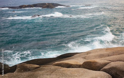 The scenery of Stone Park in Hainan, China, features emerald-green seawater crashing against the rocks, creating beautiful waves.