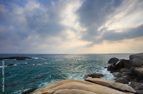 The scenery of Stone Park in Hainan, China, features emerald-green seawater crashing against the rocks, creating beautiful waves.