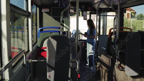Young woman boarding and paying fare on city bus