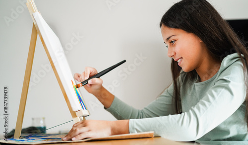 Female kid painting at home - Education, art and creativity for children concept - Main focus on face