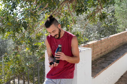 Young man taking a hydration break outdoors