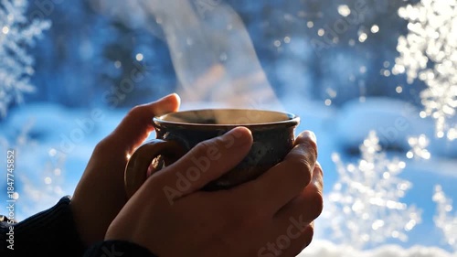 Cozy Winter Warmth - Hands Holding Hot Drink by Snowy Window.