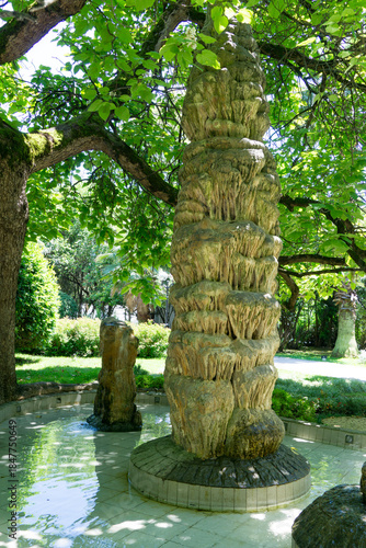 Tall stone of Stalagmite fountain in Sochi, with cascading water, surrounded by shallow pool. Created from natural stalagmites about million years old. Located in Sochi on Kurortny Prospekt