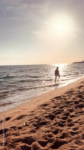 Vertical Lifestyle Video of Woman Walking on Beach at Sunset