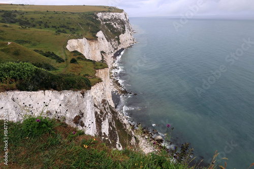 Landscape photo of the Dover chalk cliffs and the English Channel coastline against a stormy sky near Dover, United Kingdom