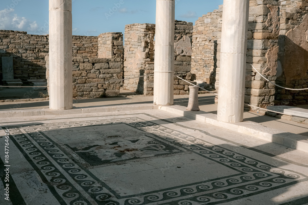 Obraz premium The house of Dionysus with towering marble columns, which rise above the foundations of the ancient house at Delos Island, Greece