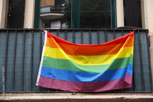 Rainbow flag LGBTQ community support symbol on a balcony in Barcelona, Spain.