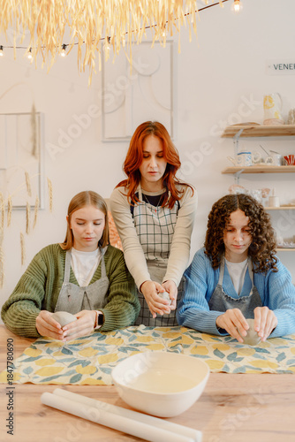 Three friends gather in a cozy studio, focusing on their pottery skills. The warm ambiance and cheerful decor add to the fun as they mold and shape their clay creations together.