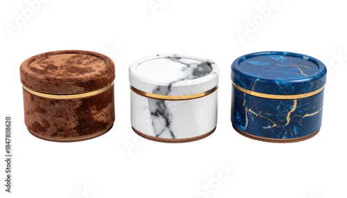 Three round, decorative boxes of various textures and colors sit side-by-side against a black background