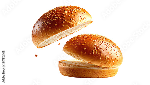 Close-up of two halves of a sesame seed bun, one slightly above the other, isolated against a solid black background