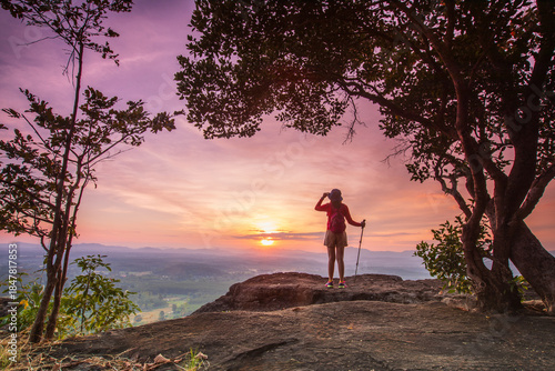 Young woman hiking on high mountain with beautiful sunset on Pha Daeng viewpoint, Na Yung Nam Som National park, Udon-Thani province , Thailand.