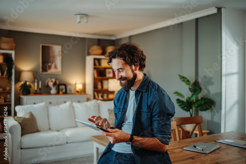 Man smiling enjoying technology browsing tablet at home