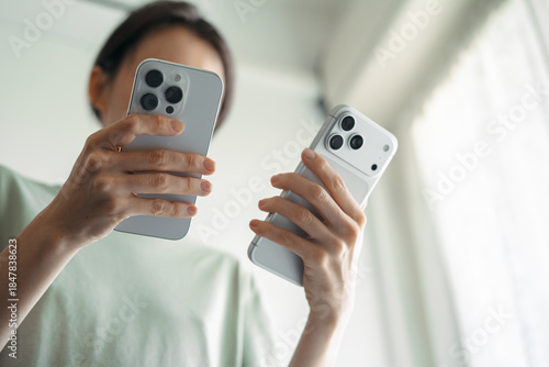 Woman comparing iPhone 16 Pro and iPhone 17 Pro Max