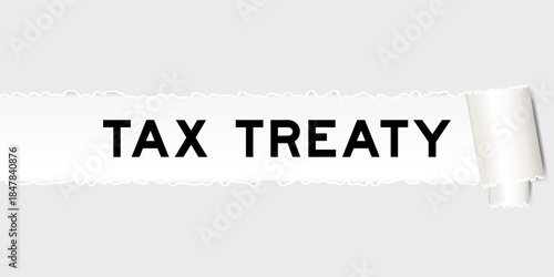 Ripped gray paper background that have word tax treaty under torn part