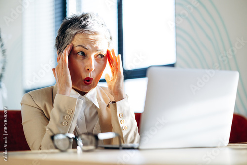 Tableau sur toile Business woman shocked while working on laptop in a cafe