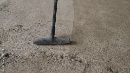 Striking contrast between a dirty, dusty concrete floor and the clean path left by a professional industrial vacuum cleaner during cleanup