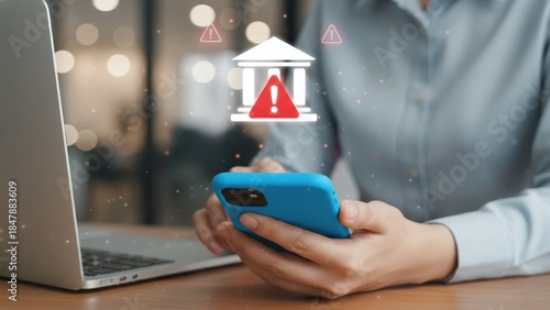 Hands holding phone with bank warning hologram above phone showing finance risk scam alert, cyber attack