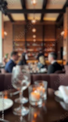Defocused background of a fine dining restaurant with blurred people, bokeh lights, and candles on a table, creating a warm and sophisticated atmosphere perfect for any out of focus concept