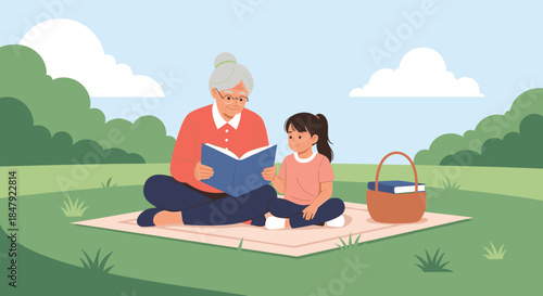 Loving grandmother sitting on a picnic blanket in a park and reading a storybook to her attentive young granddaughter.