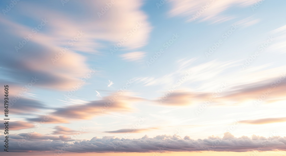 Fototapeta premium A serene, pastel-colored sky with wispy clouds and a hint of a setting or rising sun, evoking a sense of calm and tranquility.