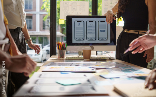 Creative UX UI designers analyzing interface concepts in a bright modern office.
