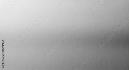 Minimalist brushed metal background with smooth silver gradient and subtle vertical line texture for modern design concepts