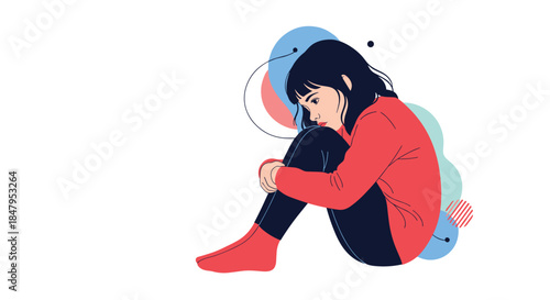 Sad and lonely young girl in a red sweater sits on the floor hugging her knees feeling depressed thoughtful or anxious.