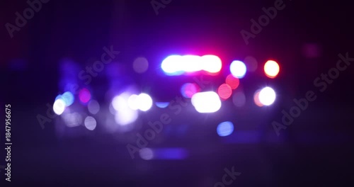 Abstracted illuminated night view of police units on a city street.