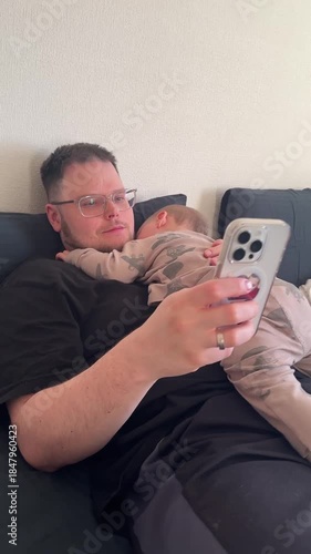 Father and Baby Relaxing with Smartphone on Couch