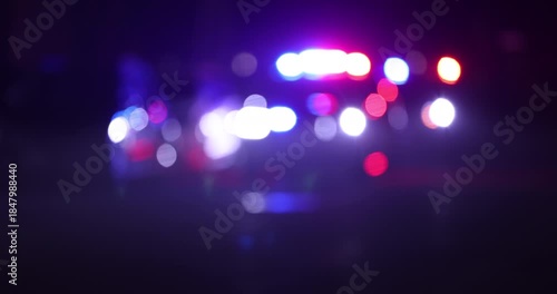 Abstracted illuminated night view of police units on a city street.