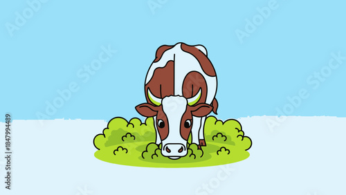 Brown and white cow grazing on green grass