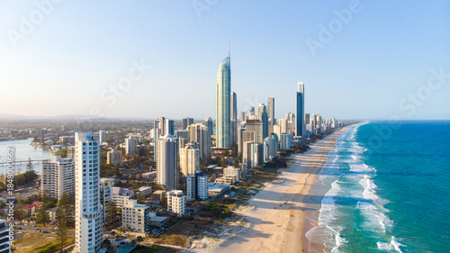 Aerial view of golden sands meet the azure sea alongside towering skyscrapers in Surfers Paradise, Queensland, Australia.