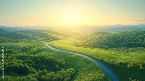 Winding road through lush green hills at sunrise