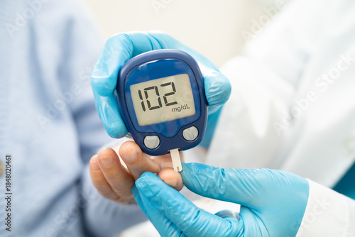 Doctor check diabetes from finger blood sugar level with finger lancet.
