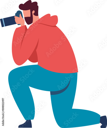 Man in a hoodie kneeling, capturing an image with a camera