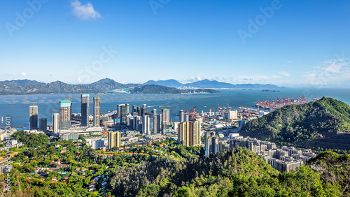 Bild auf Leinwand Panoramic view of a vibrant coastal city with port and green hills in Shenzhen