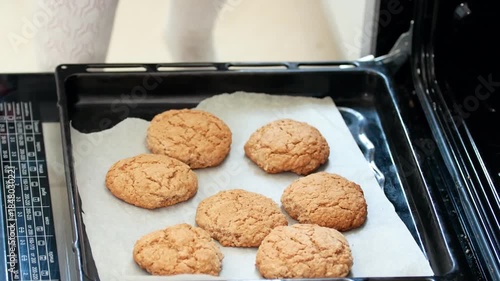 Hand in the mitten pulls out of the oven homemade cookies