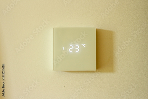 Digital thermostat showing 23 degrees celsius with a modern minimal design, for home temperature control