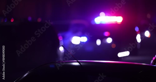 Abstracted illuminated night view of police units on a city street.