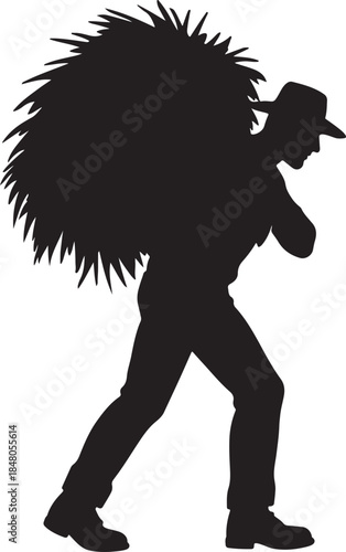 Silhouette of a rural worker carrying a large bundle of hay