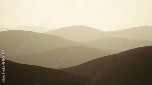 Muted layers of undulating hills create a vast tranquil landscape under a soft sky