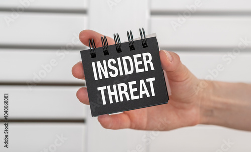 Insider Threat text on notebook in hand quote, concept background
