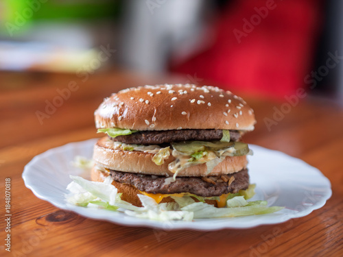 Double Cheeseburger with Fresh Vegetables on White Plate