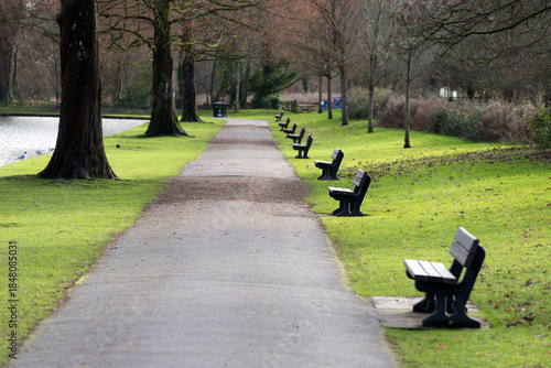 Tableau sur toile Seats lined up along the water in Warminster pleasure grounds, shallow depth of