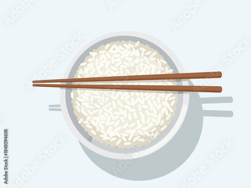 A top-down view of a bowl of white rice with chopsticks resting on top, against a light blue background