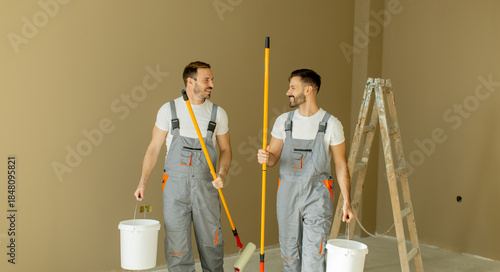 Two men painting a room tog...