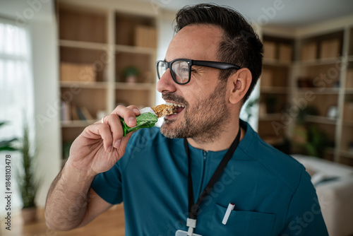 Tableau sur toile Healthcare worker eating healthy protein bar snack
