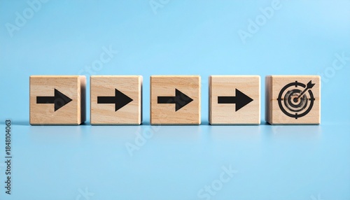 Wallpaper Mural Wooden blocks with black arrows pointing toward a target icon on the final block, blue background. Torontodigital.ca