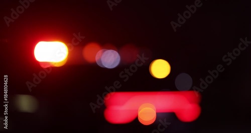 Abstracted illuminated night view of police units on a city street.